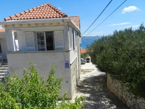 a small white house with a window on the side at Apartment Eli in Lumbarda