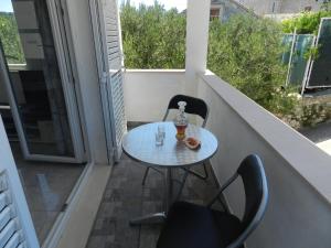 a small table and chairs on a balcony at Apartment Eli in Lumbarda +11 photos