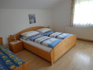 un letto in una camera da letto con struttura in legno di Ferienwohnungen Monika Unterluggauer ad Amlach
