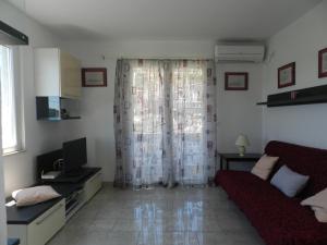 a living room with a red couch and a television at Apartment Eli in Lumbarda