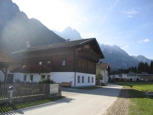 una grande casa in legno con montagne sullo sfondo di Ferienwohnungen Monika Unterluggauer ad Amlach