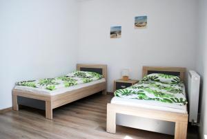 two twin beds in a room with white walls at Apart Morze apartamenty Vento in Władysławowo