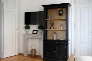 ein schwarzes Bücherregal in einem Zimmer mit einem TV in der Unterkunft Leon Apartments in Leipzig