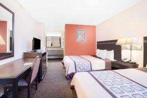 a hotel room with two beds and a desk at Americas Best Value Inn Hobbs in Hobbs