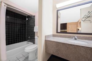 a bathroom with a sink and a toilet and a mirror at Americas Best Value Inn Hobbs in Hobbs