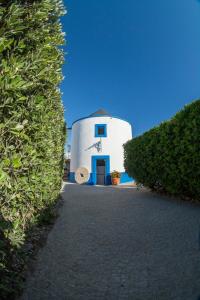 a large white building with a blue door at O Moinho da Roca in Azoia