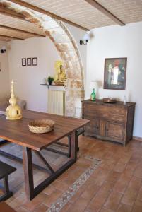 a dining room with a wooden table and a brick wall at Stone House Ilovemajella in Pretoro