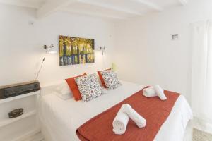 a bedroom with a white bed with towels on it at O Moinho da Roca in Azoia