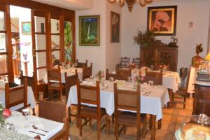 a dining room with white tables and wooden chairs at Hotel El Relicario Del Carmen in Quito