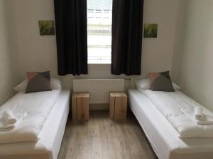 twee bedden in een kamer met een raam bij Welcome Riverside Guesthouse in Hella