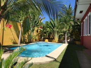 una piscina en un patio con palmeras en Alona's Coral Garden Resort (Adult-Only), en Panglao