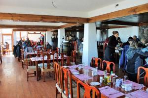 a restaurant with people sitting at tables in a room at Hotel HF in Farellones