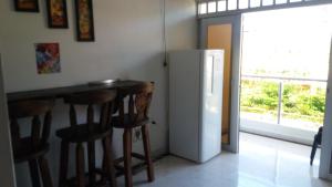 a kitchen with a bar with stools and a refrigerator at Casa Campestre La Heredera in Villavicencio