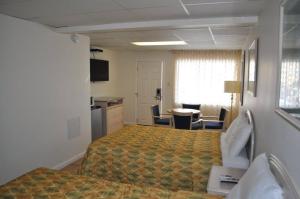 a hotel room with a bed and a desk and a kitchen at Islander Motel in Ocean City