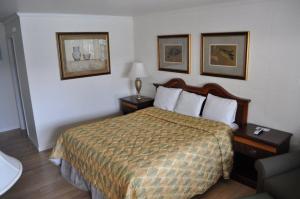 a hotel room with a bed and two pictures on the wall at Islander Motel in Ocean City +10 photos