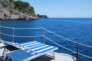 un banco azul en la parte trasera de un barco en el agua en Bed and Breakfast Da Claudio, en Conca dei Marini