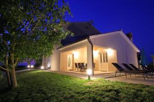 a house with chairs and a yard at night at Villa Stari Punat in Sveti Petar u Šumi