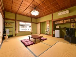 sala de estar con mesa y TV en Kikuya Ryokan, en Tonosho