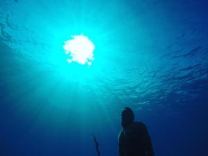 a person standing in the ocean looking up at the water at Blue Reef in San Andrés