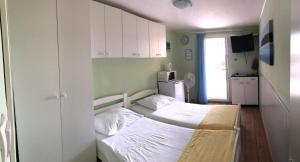 a small room with two beds and a kitchen at Apartments Villa Stella Maris in Rogoznica +102 photos