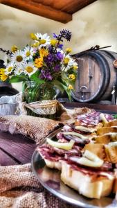 een bord met sneetjes brood op een tafel met bloemen bij Masnec Tourist Farm in Miljana