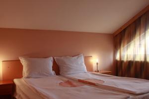 um quarto com uma cama grande e uma janela em Guest House Tabakovi em Velingrad