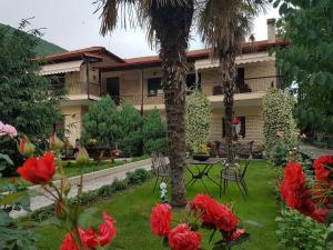 a house with a palm tree in a yard with flowers at Guest House Vaso in Orma
