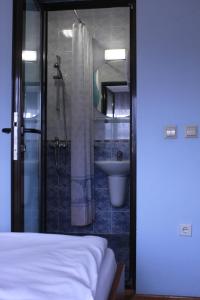 a bedroom with a bathroom with a shower and a sink at Guest House Tabakovi in Velingrad