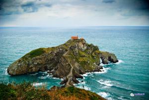 a house on top of a small island in the ocean at Mañuko Benta in Bermeo