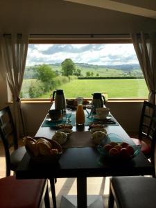 a dining room table with a view of a green field at Escale en Charolais Brionnais in Saint-Julien-de-Civry