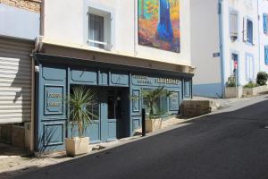 a blue store front with a potted plant in a street at Residence Hoteliere Sarah Bernard in Le Palais