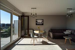 salon z kanapą, stołem i krzesłami w obiekcie Apartamenty City View od WroclawApartament-pl we Wrocławiu