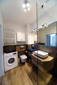 a bathroom with a washing machine and a toilet at Apartamenty City View od WroclawApartament-pl in Wrocław