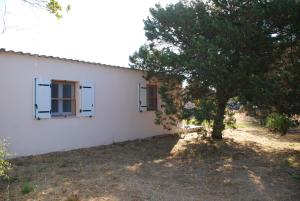 a white house with two windows and a tree at Residence Ribellinu in Pianottoli-Caldarello