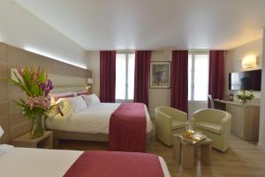 a hotel room with a bed and a tv at Unic Renoir Saint Germain in Paris