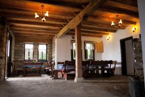 a dining room with wooden ceilings and a table and chairs at Mutafova Guest House in Veliki Preslav