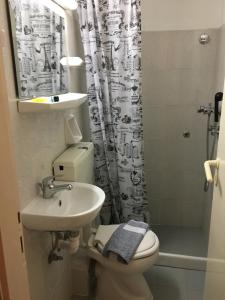 a bathroom with a sink and a toilet and a shower at Armonia Central in Loutra Edipsou +40 photos