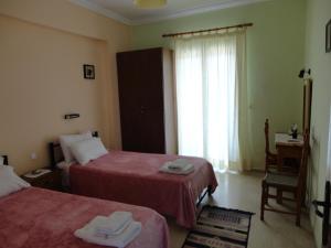 ein Hotelzimmer mit 2 Betten und einem Fenster in der Unterkunft Stamatela Studios in Paleokastritsa