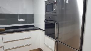 a kitchen with a refrigerator and a microwave at Casa Rural CasaBlasa in Santo Domingo de Moya