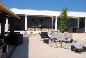 eine Terrasse mit Stühlen, einem Tisch und einem Gebäude in der Unterkunft Residence Ribellinu in Pianottoli-Caldarello