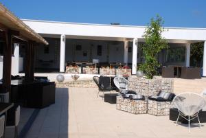 Un patio con sillas y una mesa y un edificio. en Residence Ribellinu, en Pianottoli-Caldarello