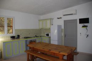a kitchen with green cabinets and a white refrigerator at Residence Ribellinu in Pianottoli-Caldarello