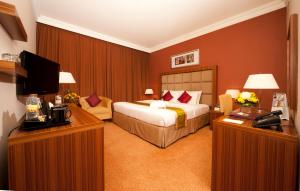 a hotel room with a bed and a television at City Seasons Al Hamra Hotel in Abu Dhabi
