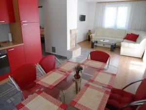 a living room with a glass table and red chairs at Galesic Apartments & Rooms in Korenica