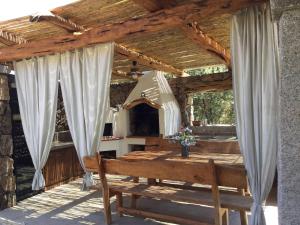 een houten pergola met een houten bank op een patio bij Il giardino di Daniela in San Teodoro