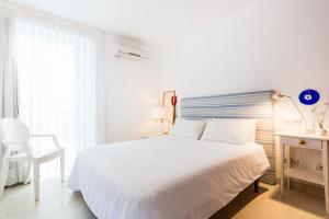 カン・ピカフォルトにあるCasa Catalina Mallorca Sea Frontの白いベッドルーム(白いベッド1台、椅子付)