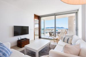a living room with a white couch and a tv at Casa Catalina Mallorca Sea Front in Can Picafort