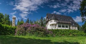 una casa blanca con un faro en una colina en Ferienwohnungen im Landhaus Wiesenbad, en Thermalbad Wiesenbad