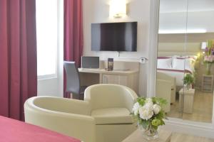 巴黎的住宿－優尼科雷諾爾聖日耳曼酒店，一间带椅子和一张书桌及电视的房间