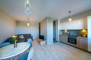 a kitchen and a living room with a table and chairs at Apartamenty City View od WroclawApartament-pl in Wrocław